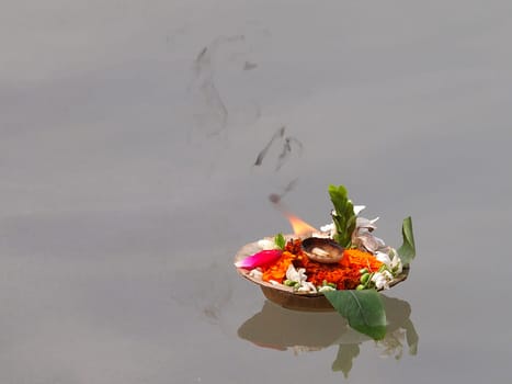 flowers and candles on the ganges river in the india