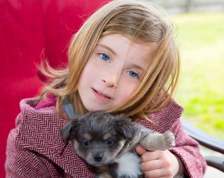 Blond girl hug a gray puppy chihuahua dog with winter coat