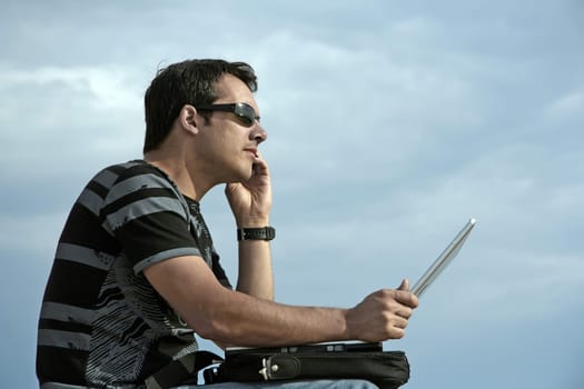 young man working on his laptop on the beach