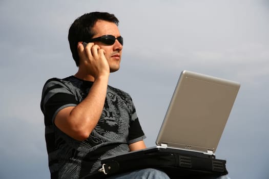 young man working on his laptop on the beach