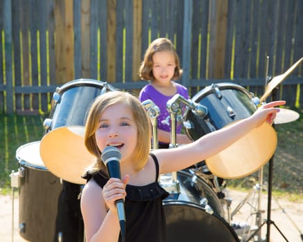 Blond kid singer girl singing playing live band in backyard concert with friends
