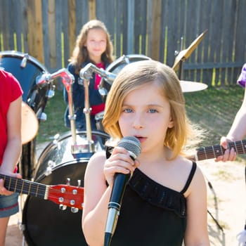 Blond kid singer girl singing playing live band in backyard concert with friends