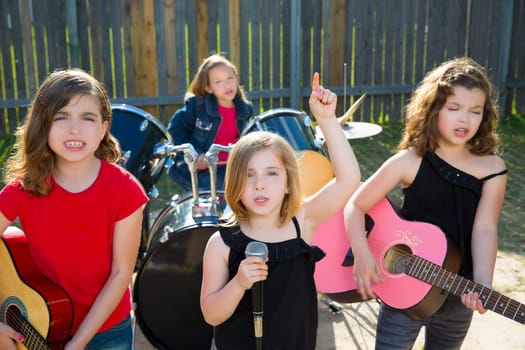 Blond kid singer girl singing playing live band in backyard concert with friends