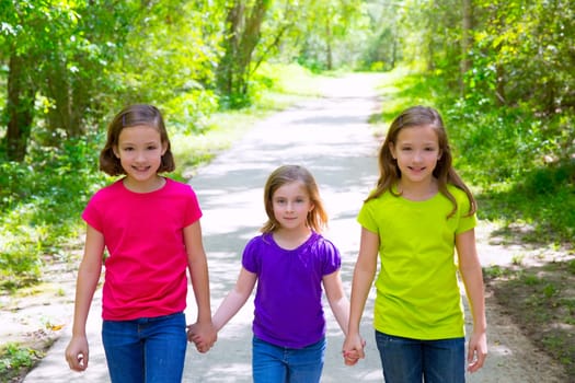 Friends and sister girls walking outdoor in forest track excursion
