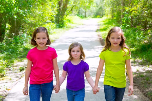Friends and sister girls walking outdoor in forest track excursion