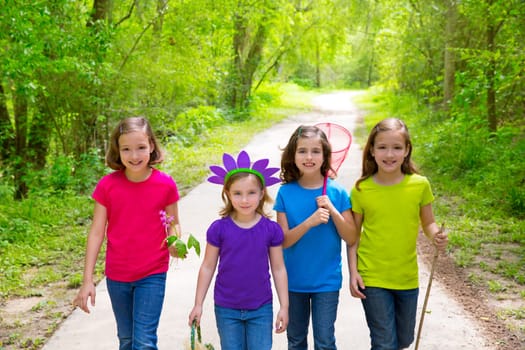 Friends and sister girls walking outdoor in forest track excursion