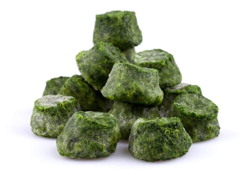 Frozen chopped spinach close-up isolated on white background.