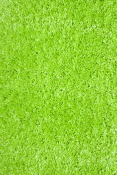 green carpet of artificial material close-up. The texture of the carpet