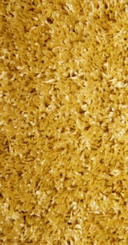 yellow carpet of artificial material close-up. The texture of the carpet