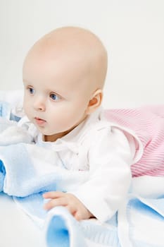 lovely blue-eyed baby with blue towel on the floor
