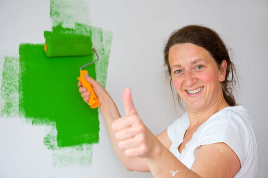 woman with paint roller and thumb up
