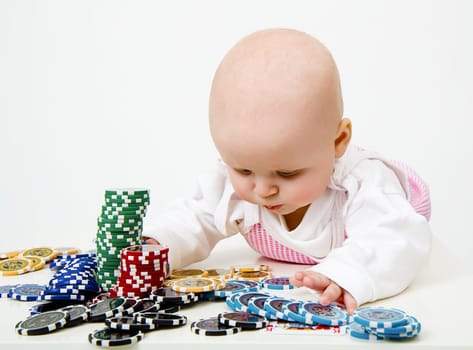 Lying on the table baby girl playing casino chips