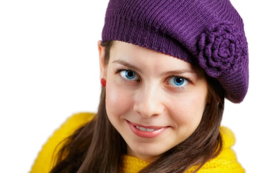Portrait of a beautiful young woman with yellow scarf and purple hat over white.