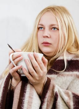 girl with a cup wrapped in a blanket. white background