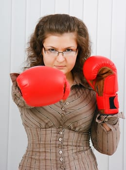 Business woman with boxing gloves in the office