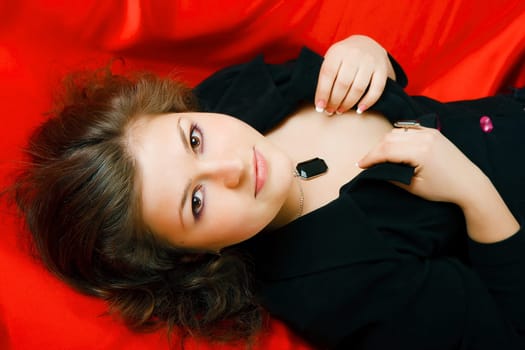 Portrait of an attractive brunette in black on red