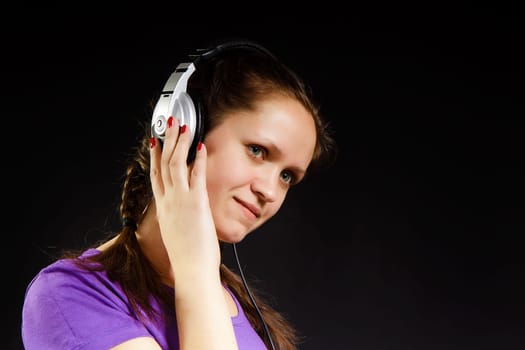 smiling girl in the headphones on a black background