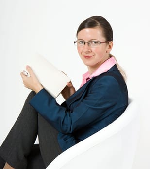 Girl with glasses sit in a chair holding a book