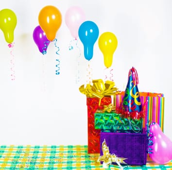pile of gifts on the table and colorful balloons. The festive mood