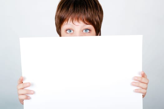 young girl hiding behind a white banner