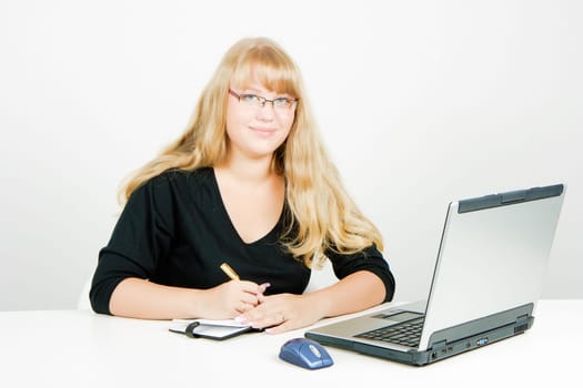 smiling blond girl with a laptop and notebook