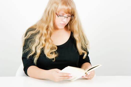 blonde girl with glasses reading a book