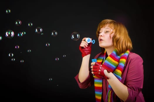girl with soap bubbles on a black background