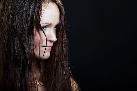 beautiful girl with long wet hair on a black background