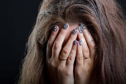 girl with wet hair in despair covers her face