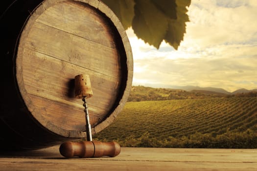 corkscrew and wooden barrel, vineyard on background