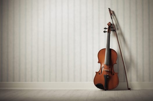 Violin and bow on a vintage wallpaper