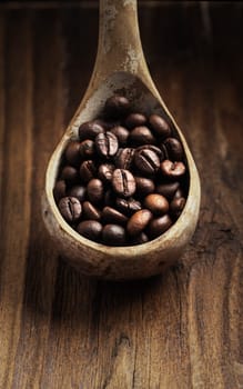 Close up of wooden spoon with coffee beans on it