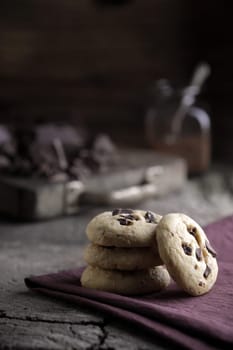 Stack of chocolate chip cookies with ingredients in the background