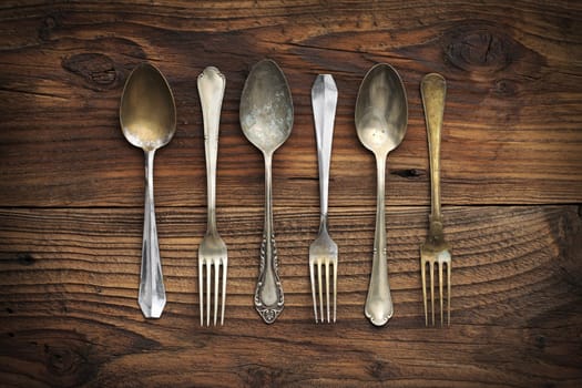 Old forks and spoons on wooden background