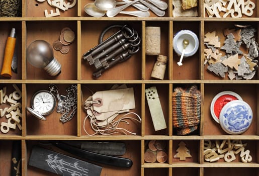 group of old objects in a drawer with compartments