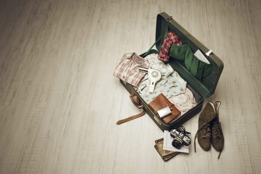 Vintage suitcase open on a wood floor in an empty room