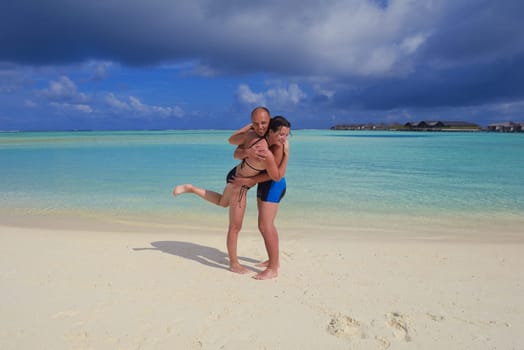 happy young couple have fun and relax at summer vacation on background maldives travel location and beautiful white sand beach