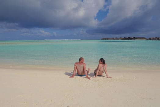 happy young couple have fun and relax at summer vacation on background maldives travel location and beautiful white sand beach