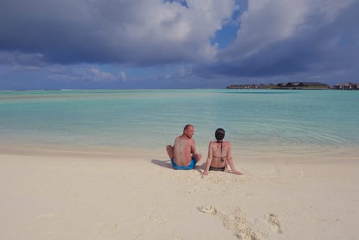 happy young couple have fun and relax at summer vacation on background maldives travel location and beautiful white sand beach