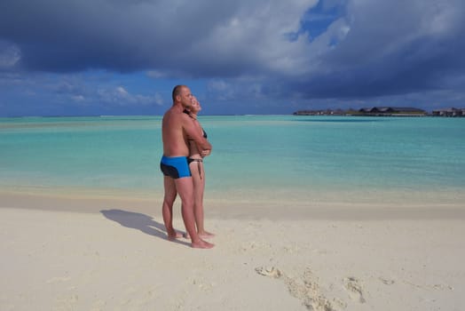 happy young couple have fun and relax at summer vacation on background maldives travel location and beautiful white sand beach
