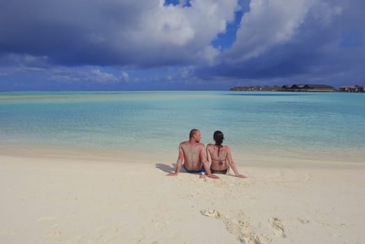 happy young couple have fun and relax at summer vacation on background maldives travel location and beautiful white sand beach