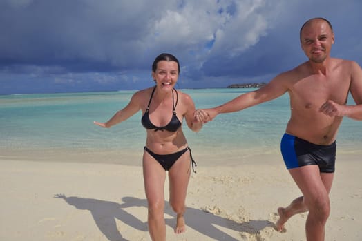 happy young couple have fun and relax at summer vacation on background maldives travel location and beautiful white sand beach