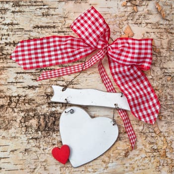 Heart with checkered bow on birch bark background
