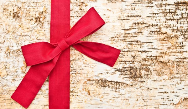 Birch bark background with large red ribbon