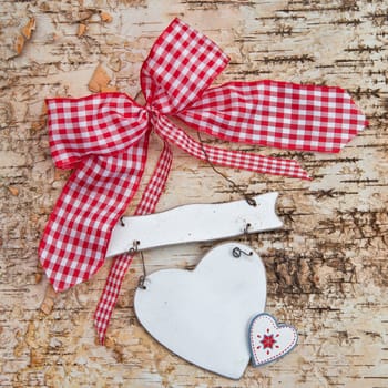 Heart with checkered bow on birch bark background