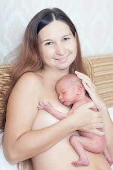 Mother holding a newborn baby skin-to-skin contact