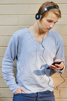 Young male scrolling through song list with sun highlighting mp3 player
