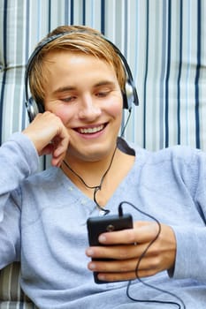 Good looking young male checking out song list on phone.