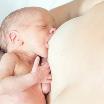 Mother breastfeeding a newborn baby skin-to-skin contact
