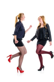 Two teenager girls having a party an dacing together isolated against white background.